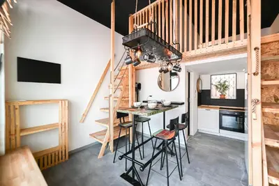 a loft conversions kitchen with a bar and stairs at Apartma N'Poznam župa in Ljubljana
