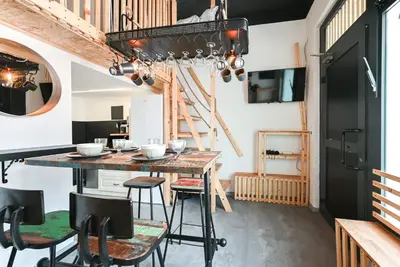 a kitchen with a table and chairs and a chandelier at Apartma N'Poznam župa in Ljubljana