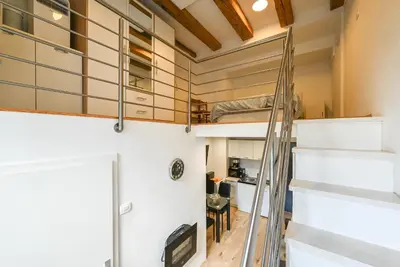 a room with a ladder leading up to a bunk bed at Apartma N'Poznam Tobačna 2 in Ljubljana