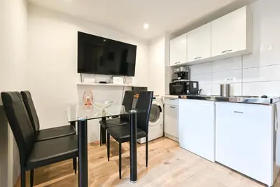 a kitchen with a table with chairs and a microwave at Apartma N'Poznam Tobačna 2 in Ljubljana