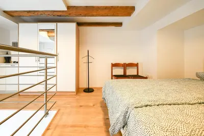 a bedroom with a bed and a staircase at Apartma N'Poznam Tobačna 2 in Ljubljana