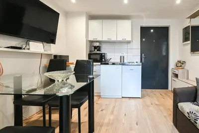 a kitchen and living room with a glass table and chairs at Apartma N'Poznam Tobačna 2 in Ljubljana
