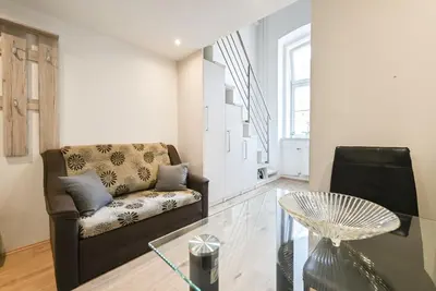 a living room with a couch and a glass table at Apartma N'Poznam Tobačna 2 in Ljubljana