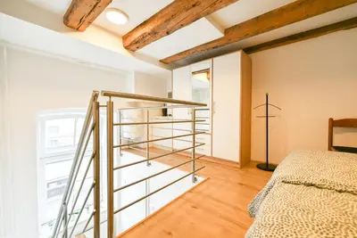 a glass staircase in a room with a bed at Apartma N'Poznam Tobačna 2 in Ljubljana