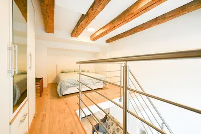 a room with a bed and a glass staircase at Apartma N'Poznam Tobačna 2 in Ljubljana