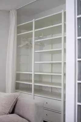 a white closet with white shelves and a bed at Apartment Sturje in Ajdovščina