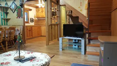 a living room with a television and a staircase at Holiday Home Prdelanca in Luče
