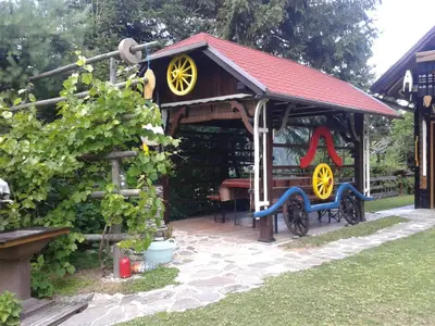 a gazebo with a bench and a table at Holiday Home Prdelanca in Luče