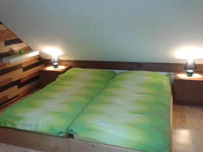 a bed in a room with two lamps on tables at Holiday Home Prdelanca in Luče