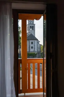 an open door with a view of a church at PosestvoRavbar in Dutovlje