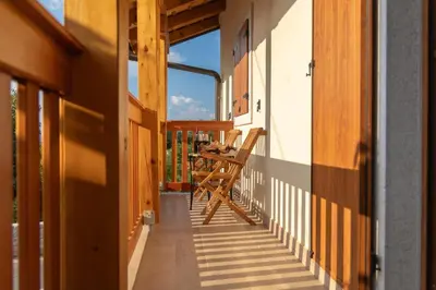 a balcony with a table and chairs on it at PosestvoRavbar in Dutovlje