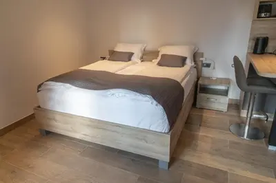 a large bed in a room with a desk at PosestvoRavbar in Dutovlje