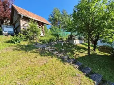a yard with a tree and a house at Idyllisches Haus in der Natur in Šoštanj