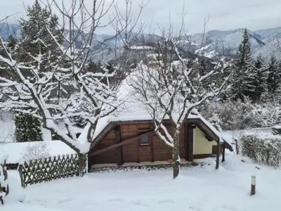 a cabin with snow on the roof of it at Idyllisches Haus in der Natur in Šoštanj