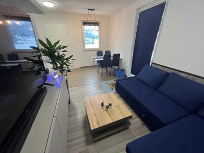 a living room with a blue couch and a table at Apartment Adam & Eva, Near terme Olimia, Free Parking in Podčetrtek