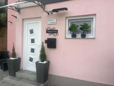 a pink building with two potted plants next to a door at Apartment Adam & Eva, Near terme Olimia, Free Parking in Podčetrtek