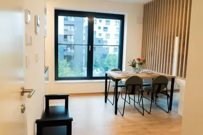 a dining room with a table and chairs and a window at Ella's Cozy place in Ljubljana