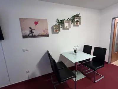 a dining room with a white table and black chairs at Apartmaji Irma in Moravske Toplice
