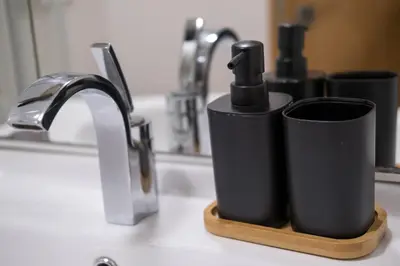 two black cups on a wooden holder next to a sink at Apartmaji Irma in Moravske Toplice