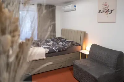 a bedroom with a bed and a chair and a window at Apartmaji Irma in Moravske Toplice