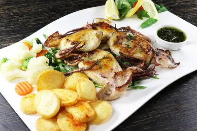 a plate of food with chicken and potatoes and vegetables at Gostisce Sobocan in Maribor