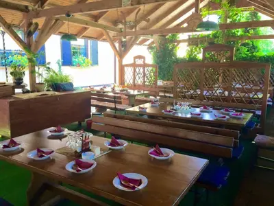 a restaurant with wooden tables and benches with food on them at Gostisce Sobocan in Maribor