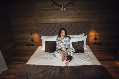 a woman sitting on top of a bed at Vila Muhr in Bohinj