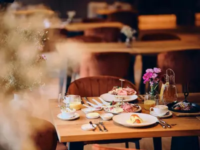 a wooden table with plates of food on it at Vila Muhr in Bohinj