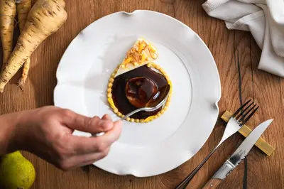 a hand holding a plate with a piece of food at Vila Muhr in Bohinj