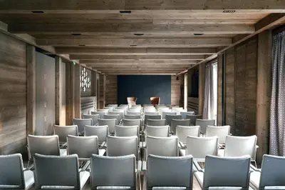 an empty room with white chairs in front of a screen at Vila Muhr in Bohinj