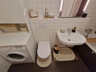 a white bathroom with a sink and a toilet at Waldorf Apartment in Ljubljana