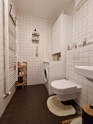 a white bathroom with a toilet and a sink at Waldorf Apartment in Ljubljana