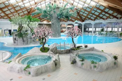 a large swimming pool with two hot tubs in a building at Holiday home Isabella in Terme Čatež in Čatež ob Savi
