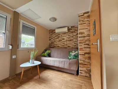 a living room with a couch and a brick wall at Holiday home Isabella in Terme Čatež in Čatež ob Savi
