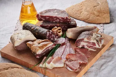 a plate of different types of bread and meats at Farmstay&Glamping Visočnik in Ljubno