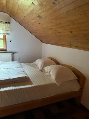 a bed in a room with a wooden ceiling at Chalet Neva in Loče pri Poljčanah