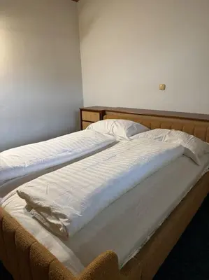 a bedroom with two beds with white sheets at Chalet Neva in Loče pri Poljčanah