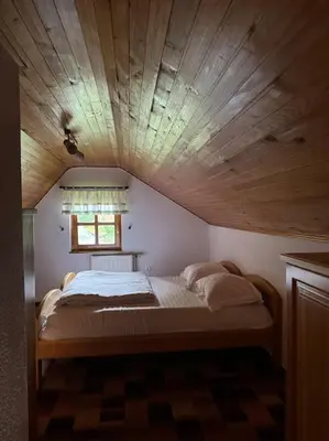 a bed in a room with a wooden ceiling at Chalet Neva in Loče pri Poljčanah