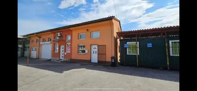 an orange building with two garages in a parking lot at Chic Loft with Open Floor Plan in Spodnja Šiška