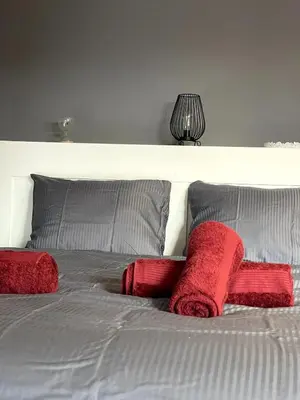 a bed with two red pillows and a white headboard at Chic Loft with Open Floor Plan in Spodnja Šiška