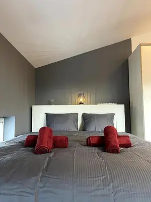 a bedroom with a large bed with red pillows at Chic Loft with Open Floor Plan in Spodnja Šiška