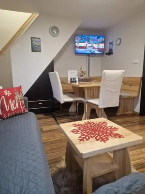 a room with a table and chairs and a tv at Madeira House - Terme Čatež in Čatež ob Savi