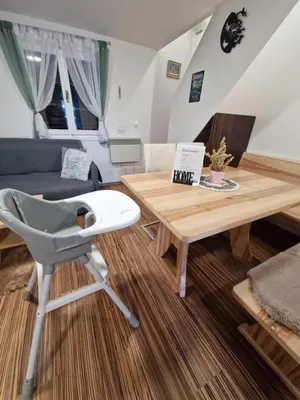 a living room with a table and a chair at Madeira House - Terme Čatež in Čatež ob Savi