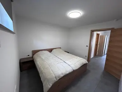 a bedroom with a bed in the corner of a room at Apartment Angelina in Cerklje na Gorenjskem