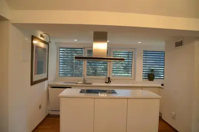 a kitchen with white cabinets and a sink and windows at Delux apartment at Robida Estate in Dolenjske Toplice