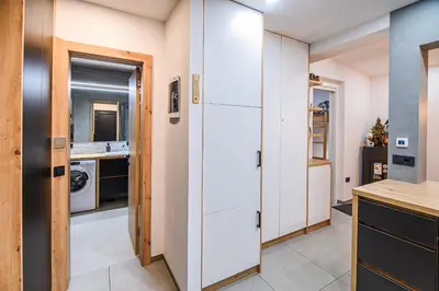 a kitchen with white cabinets and a washer and dryer at Panorama Krvavec Ski-in, Ski-out in Cerklje na Gorenjskem