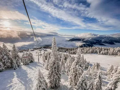 a ski lift with snow covered trees on a mountain at Panorama Krvavec Ski-in, Ski-out in Cerklje na Gorenjskem