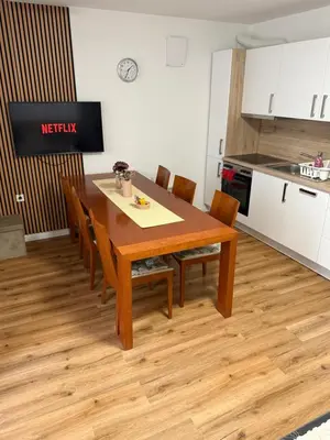 a dining room table with chairs and a kitchen at La Hiška Čatež with Tickets - each guest gets 2 entries per day in Čatež ob Savi