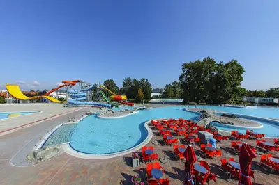 a swimming pool with red and blue chairs and a water park at La Hiška Čatež with Tickets - each guest gets 2 entries per day in Čatež ob Savi