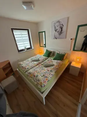 a bedroom with a large bed with green pillows at La Hiška Čatež with Tickets - each guest gets 2 entries per day in Čatež ob Savi